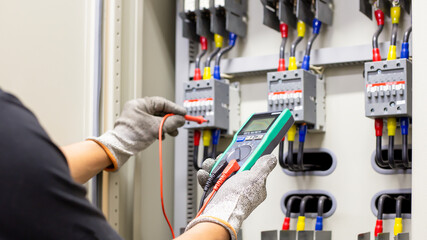 Engineers working to inspect and maintain electrical control cabinets.