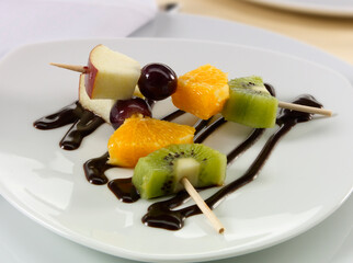 Brochetas de kiwi, naranja, cereza y manzana con chocolate. Kiwi, orange, cherry and apple skewers with chocolate.