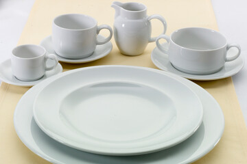 Fototapeta na wymiar Menaje de porcelana blanca, platos, tazas y jarra