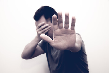 Man raising a hand to prohibit or cover her face to show resistance