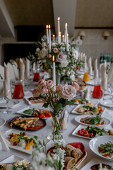 Wedding table with food and decoration for guests by candlelight