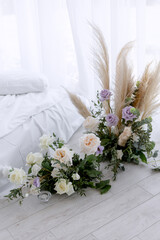 Decorative flowers near white bed for young couple