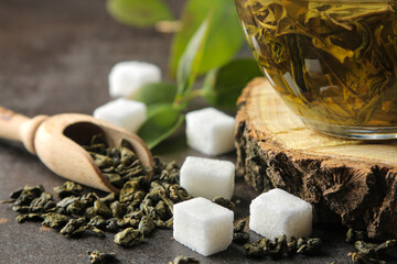 Green tea. Dry tea leaves and hot tea in a cup on a dark background