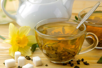 Green tea. Hot tea in a cup with mint and a teapot on a wooden background. close-up