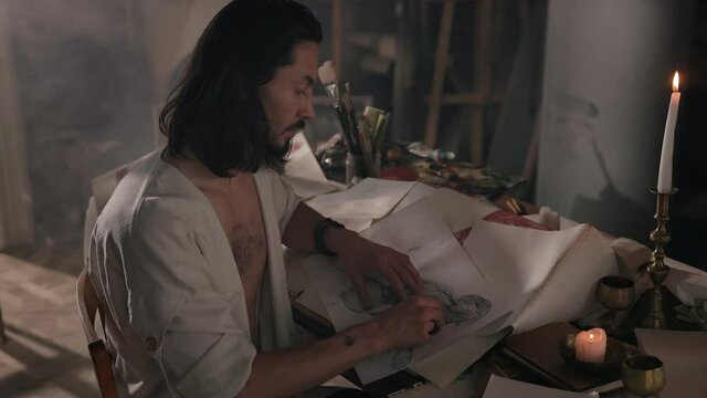Young Artist In Art Studio. Cute Young Man With Long Hair. He Is Painting.
