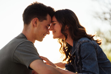 Friendly couple on a date outdoors in the city park, sit on skateboards