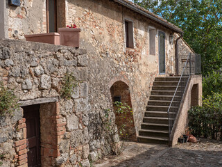 Fototapeta na wymiar Ancient Farmhouse and Rural Dwelling with outdoor Stairs in the Medieval Village of Monteriggioni, Siena - Italy