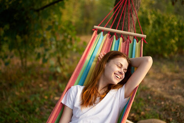 cheerful woman lies in a hammock in nature sun rest