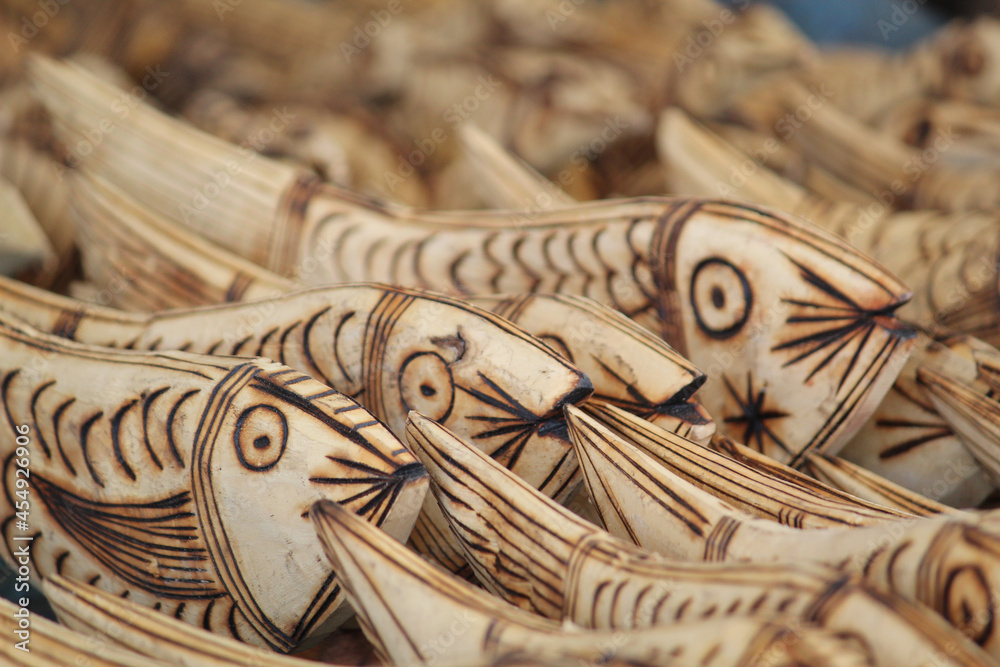 Sticker beautiful closeup of wooden handcraft fish structures being sold at the market