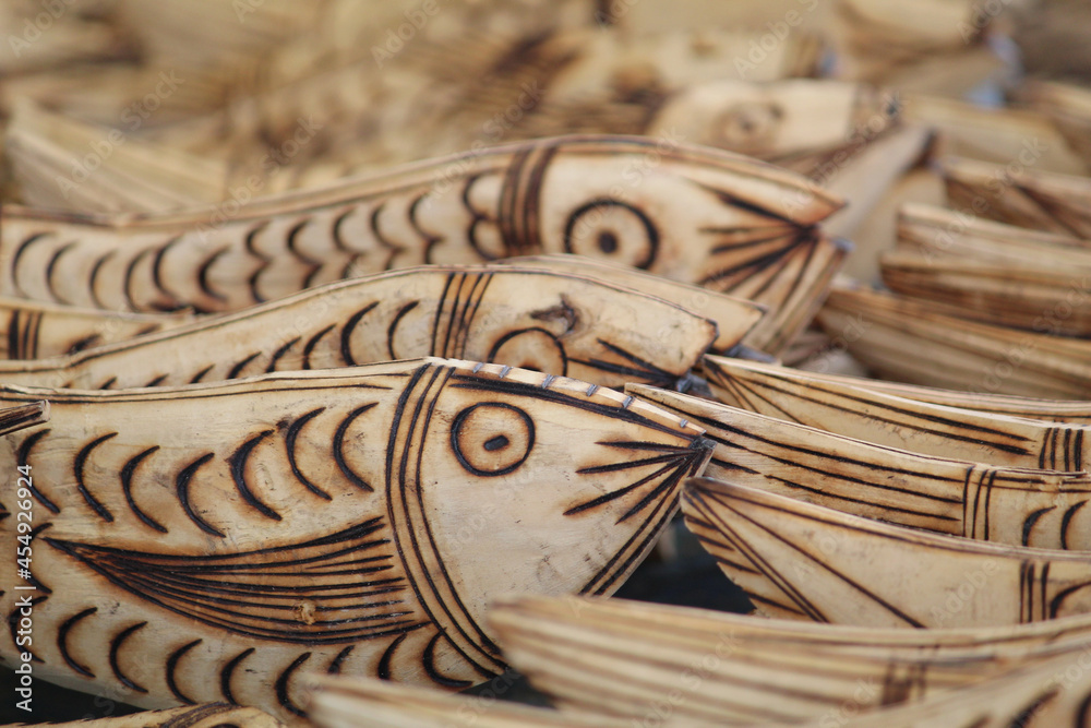 Sticker beautiful closeup of wooden handcraft fish structures being sold at the market