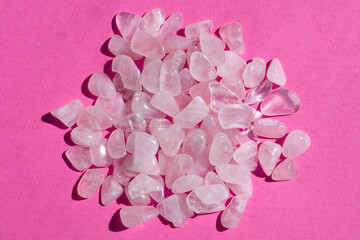 Several pieces of polished pink quartz on textured pink background. Minimal color still life...