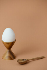 white boiled egg in a wooden egg cup with copy space 