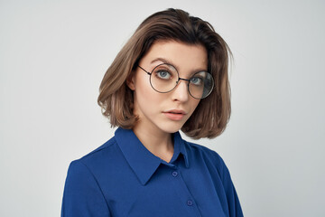 woman blue shirts with glasses fashion posing light background