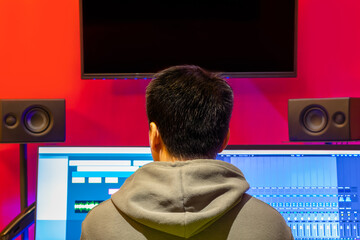 back of music producer, sound engineer listening audio from monitor speakers