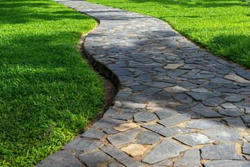 Garden stone walkway among green grass - 454931994