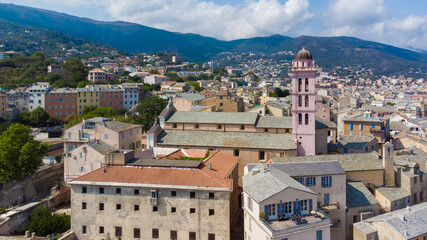 Fototapeta na wymiar Aerial view of the Citadel of Bastia in the north of Corsica island - Pink bell tower of the Cathedral of Saint Mary of the Assumption over the Mediterranean Sea