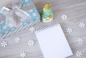 A notebook,a Christmas tree and a gift on the table.The concept of planning. New Year, Christmas