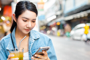 Traveler Asian woman friend travel in Bangkok, Thailand, sweet couple taking photo . Lifestyle couple travel in city concept.Young fun happy Asian tourist backpacker travel eating street food.