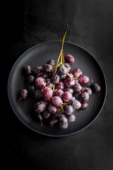 Plate with fresh red grapes