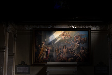 Large painting inside a church illuminated by the sunlight coming in through the windows