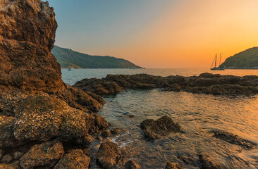 Fototapeta na wymiar Beautiful sunset on the rock beach.