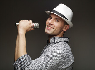lifestyle and people concept: young singer man with microphone