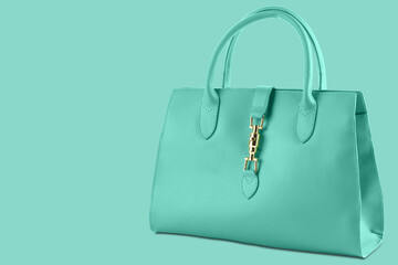 turquoise womens bag with handles, on a turquoise background, diagonal arrangement, concept