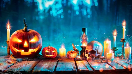 Foto op Plexiglas Halloween At Night - Jack O Lantern On Table With Candles In Forest © Romolo Tavani