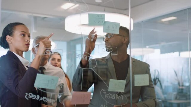 business people using sticky notes brainstorming team leader woman writing on glass whiteboard working with colleagues showing problem solving strategy in office meeting