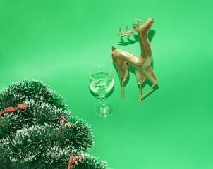 Beautiful  Christmas golden reindeer toy isolated on green background, little  decoration, Christmas tree bauble,Minimal winter holidays idea. Flat lay top view composition. Christmas concept.