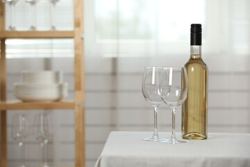 Bottle of wine with two glasses on table indoors
