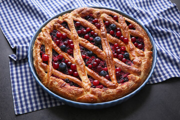 Delicious currant pie and fresh berries on grey table