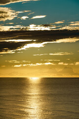 分厚い黒い雲がパレットのように色を分ける浮世絵の世界のような色をした夕景の日本海