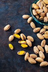 Roasted pistachios nuts on dark background. Pistachio - healthy vegetarian protein nutritious food. Healthy snack. Copy space. Top view