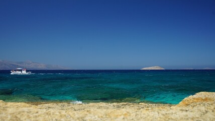Sea and sky as a wave splash appears on the cliff in the Greek island of koufonisi August 2021