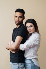 Love, new mixed race parents and family concept - very happy couple, celebrating the news of a pregnancy. Beige background.