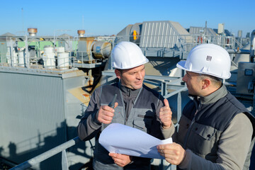 2 engineers check oil refinery