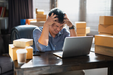 Tired young man from computer work,stressed man suffer from headache bad vision sight problem sit at home table using laptop ,  holding his head on hands , and worried business