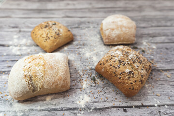 Assorted breads on a gray wooden table.