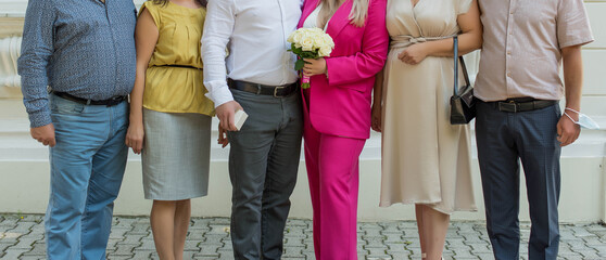 People's bodies and legs stand together. Holiday, wedding, family.
