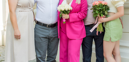 People's bodies and legs stand together. Holiday, wedding, family.