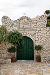 Fototapeta na wymiar August 18th 2020 - Corfu, Greece - The gate to the monastery of Panagia Mirtidion, Myrtiotissa bay, Corfu, Greece