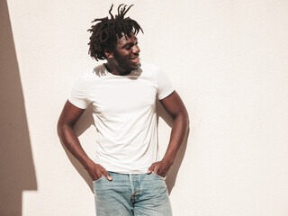 Portrait of handsome hipster model.Unshaven African man dressed in white summer t-shirt and jeans....
