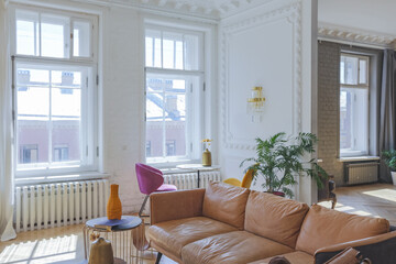 luxury interior of a spacious apartment in an old 19th century historical house with modern furniture. high ceiling and walls are decorated with stucco