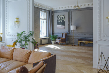 luxury interior of a spacious apartment in an old 19th century historical house with modern furniture. high ceiling and walls are decorated with stucco