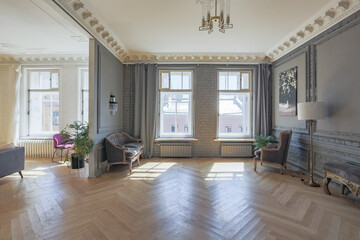 luxury interior of a spacious apartment in an old 19th century historical house with modern furniture. high ceiling and walls are decorated with stucco