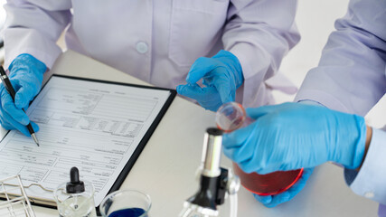 Team of Medical Research Scientists or researcher in lab coat testing their experimental in Modern...