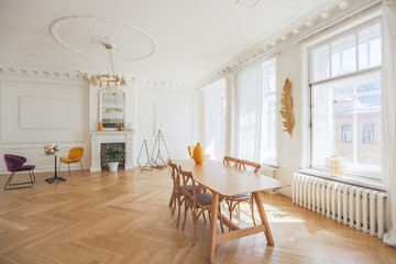 luxury interior of a spacious apartment in an old 19th century historical house with modern furniture. high ceiling and walls are decorated with stucco