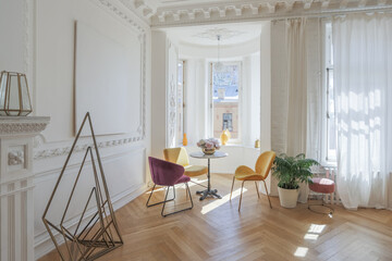 luxury interior of a spacious apartment in an old 19th century historical house with modern furniture. high ceiling and walls are decorated with stucco