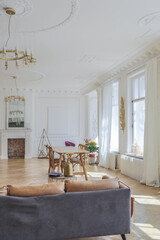 luxury interior of a spacious apartment in an old 19th century historical house with modern furniture. high ceiling and walls are decorated with stucco